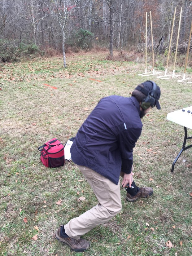 A fellow student accessing a revolver in an ankle holster.
